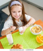 stock-photo-smiling-little-girl-eating-egg-in-the-kitchen-131859545.jpg